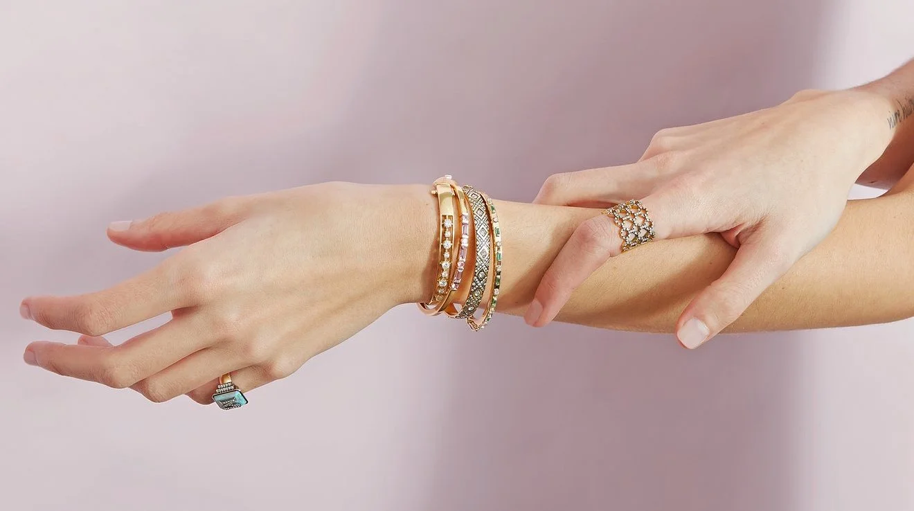 Female hand showcasing an assortment of stylish bracelets.